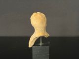 a small sculpture of a head on a black stand