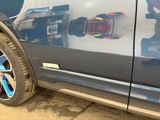 a close up of a car ' s side door with the reflection of a building