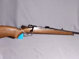 le fusil repose sur un chapeau, sur un fond blanc