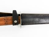 a knife with a wooden handle on a white surface