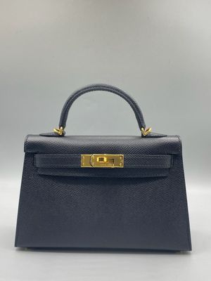 un sac à main en cuir bleu avec des finitions dorées sur la poignée