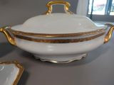 a white bowl with gold trim and a gold handle