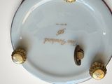 a white plate with gold decorations on it with a name on it