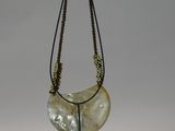 an image of a necklace with a shell on a stand