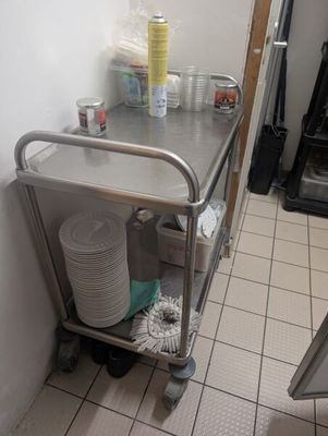 a metal cart with plates and cups on it in a kitchen