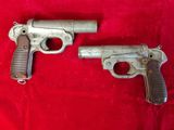 un vieux pistolet et un plus petit sur un tissu rouge