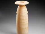 an old vase sitting on top of a table on a gray surface