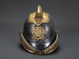 an old helmet with a gold decoration on the top