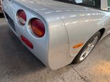 a silver sports car parked in a garage with other cars in the background