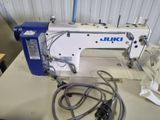 a white and blue sewing machine sitting on a table