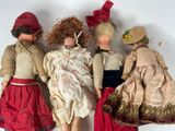 three dolls of different sizes are lined up against a white wall