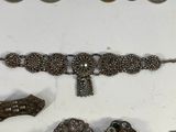 a lot of silver jewelry on display on a table