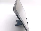 a tablet computer sitting on a stand on a white surface
