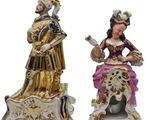 two figurines of a woman and a man sitting on a bench