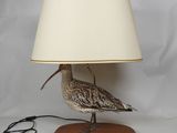 une image représentant une lampe en forme d'oiseau avec un abat-jour blanc sur la tête