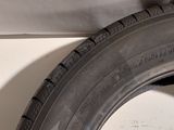 a close up of a tire on the side of a white wall