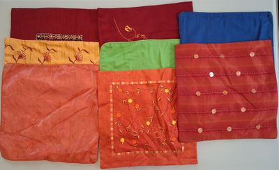 Quatre saris de couleurs différentes sont alignés sur une table