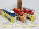 quatre camions de pompiers miniatures posés sur une boîte en carton
