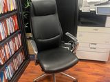 a black office chair in front of a bookshelf