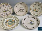 four plates with birds and flowers on them sitting on a table