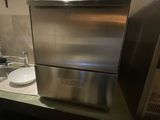 a stainless steel dishwasher sitting on a counter in a kitchen