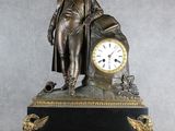 une statue d'un homme tenant une horloge au-dessus d'une table
