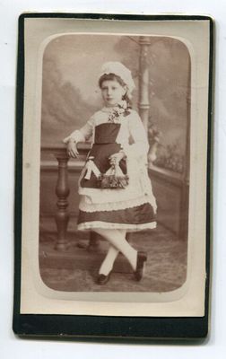 une vieille photo d'une femme en robe et avec un chapeau