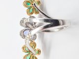 an image of a silver ring with green and white stones