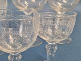 four wine glasses sitting on a table with a blue table cloth