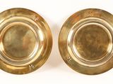 pair of antique brass plates on a white background