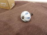 a white and blue ceramic knob on a brown cloth