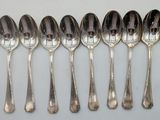 six spoons are lined up in a row on a white surface