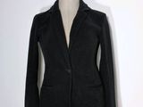 un blazer noir sur un mannequin, sur fond blanc