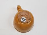 a brown cup with writing on it sitting on a white surface