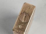 a gold bar that is sitting on a white surface