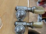 a close up of a guitar neck with a lot of knobs