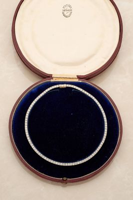 a diamond necklace in a velvet case on a table