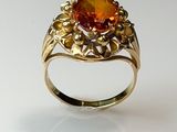 bague en or jaune sertie d'une topaze orange entourée de feuilles
