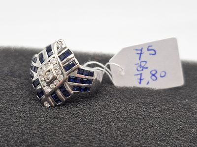 bague en argent ornée de pierres bleues et sur laquelle est accrochée une étiquette de prix