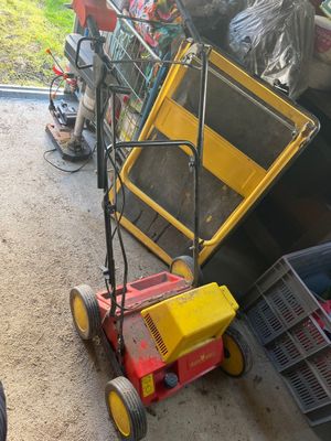 a lawn mower that is sitting on the ground next to a pile of trash