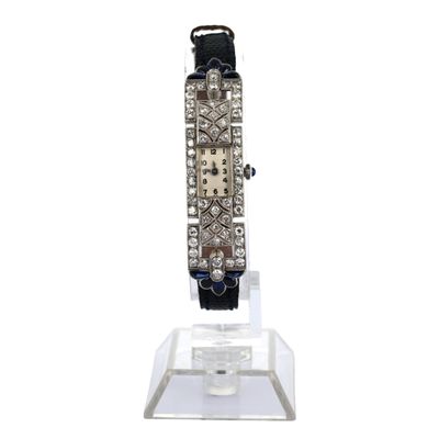 un gros plan d'une montre posée sur un socle transparent, sur fond blanc
