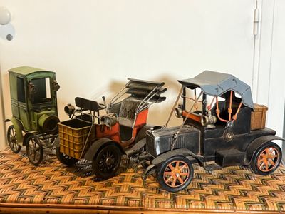 deux voitures miniatures d'un ancien modèle posées côte à côte sur une table