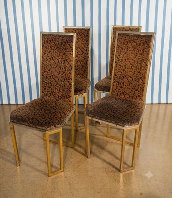 trois chaises recouvertes d'un tissu à imprimé léopard, placées devant un mur rayé