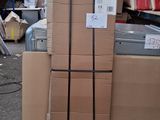 des cartons empilés les uns sur les autres à même le sol dans un entrepôt