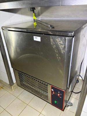 a stainless steel refrigerator in a kitchen with tile flooring