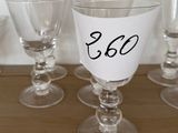 six verres à vin posés sur une table, chacun portant un numéro