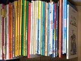une étagère sur laquelle sont posés tout un tas de livres pour enfants
