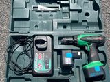 a green tool box with tools in it on the ground