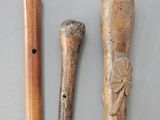 deux cannes en bois ornées de sculptures, posées l'une à côté de l'autre