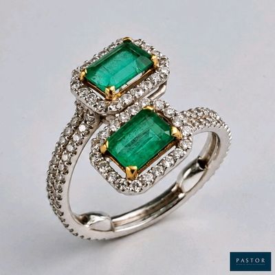 un gros plan d'une bague sertie de deux émeraudes